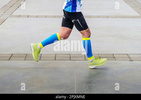 Beine Sportler Läufer in Kompressionssocken Laufmarathon Distanz, bunte Sportbekleidung Stockfoto