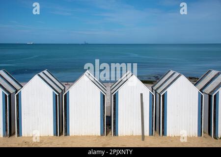 Yport, Strandhütten am Meer. Die Entstehung des Offshore-Windparks Fécamp im Hintergrund Stockfoto