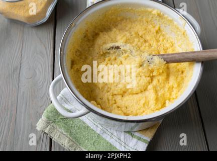 Topf mit frisch gekochter Polenta, traditioneller italienischer Beilage mit Brühe, Milch, Butter und Parmesankäse Stockfoto