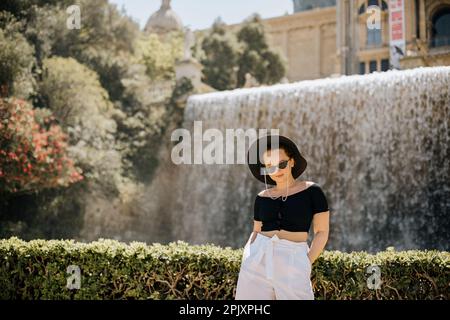 Ein wunderschönes Mädchen steht vor dem Hintergrund von Barcelona und genießt die Reise. Eine Frau, die auf die Stadt blickt. Schloss Montjuic oder Castell de Montjuic Stockfoto