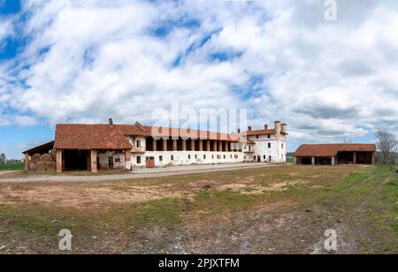 Ein alter verlassener Bauernhof mit Scheunen über den Ställen und dem befestigten Herrenhaus, typische ländliche Architektur der Ebene des Po-Tals im Provin Stockfoto