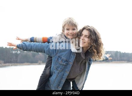 Teenager Mädchen und Junge 6 Jahre alt, Erwachsene Schwester und jüngerer Bruder spielen während der Ferien in der Natur zusammen, Wellness, positives Denken, gute Laune Stockfoto