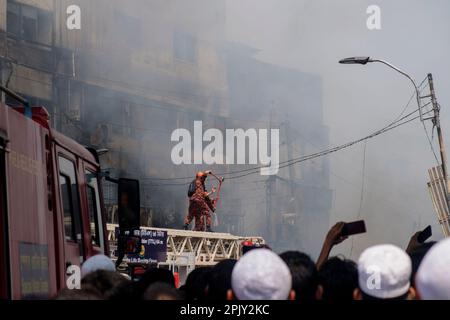 Feuerwehrleute durchtrennen Kabel, um Zugang zu erhalten. Im Morgengrauen des 4. April 2023 brach in Bangabazar, einem der größten Stoffmärkte in Dhaka, Bangladesch, ein massives Feuer aus. Dem Vernehmen nach begann der Brand in einer der Läden um ca. 6 UHR MORGENS und breitete sich schnell auf den Rest des Marktes aus. Das Feuer wütete fast 7 Stunden lang, bevor es unter Kontrolle gebracht wurde. Der Brand hat erhebliche Schäden am Markt verursacht, wobei die meisten Läden und Verkaufsstände durch die Flammen zerstört wurden. (Foto: Rizwan Hasan/Pacific Press) Stockfoto