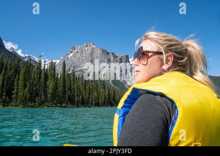 Eine besorgte blonde Frau schaut in die Ferne, denkt und reflektiert während einer Kanufahrt auf dem Emerald Lake im Yoho National Park Canada