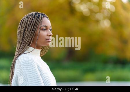 Eine ernsthafte afrikanerin, die in einem Park aufschaut Stockfoto