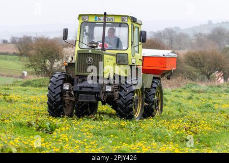 Timoleague, West Cork, Irland. 4. April 2023. David Deasy, der Milchbauer aus Timoleague, verteilt auf seinem 30 Hektar großen Feld mit einem 1984 MB Trac 900 und einem Rauch MDS 18,2 Düngerstreuer geschützten Harnstoffdünger. Kredit: AG News/Alamy Live News Stockfoto