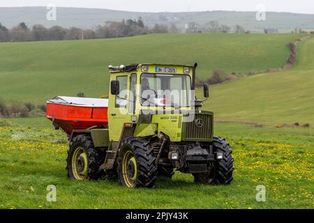 Timoleague, West Cork, Irland. 4. April 2023. David Deasy, der Milchbauer aus Timoleague, verteilt auf seinem 30 Hektar großen Feld mit einem 1984 MB Trac 900 und einem Rauch MDS 18,2 Düngerstreuer geschützten Harnstoffdünger. Kredit: AG News/Alamy Live News Stockfoto