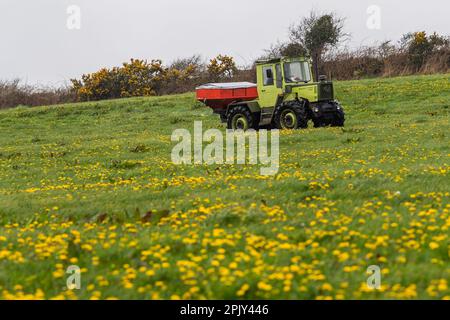 Timoleague, West Cork, Irland. 4. April 2023. David Deasy, der Milchbauer aus Timoleague, verteilt auf seinem 30 Hektar großen Feld mit einem 1984 MB Trac 900 und einem Rauch MDS 18,2 Düngerstreuer geschützten Harnstoffdünger. Kredit: AG News/Alamy Live News Stockfoto