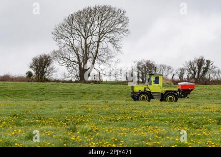 Timoleague, West Cork, Irland. 4. April 2023. David Deasy, der Milchbauer aus Timoleague, verteilt auf seinem 30 Hektar großen Feld mit einem 1984 MB Trac 900 und einem Rauch MDS 18,2 Düngerstreuer geschützten Harnstoffdünger. Kredit: AG News/Alamy Live News Stockfoto