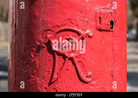 VR Cypher (viktorianisch) auf einem rot gestrichenen Postfach in Norbiton, Surrey Stockfoto