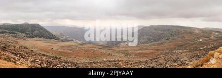 Breites Panorama des Dana Biosphärenreservats in Jordanien, grau bedeckter Wolken über großer Schlucht Stockfoto