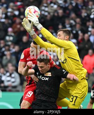 04. April 2023, Hessen, Frankfurt/Main: Fußball: DFB Cup, Eintracht Frankfurt - 1. FC Union Berlin, Viertelfinale, Deutsche Bank Park. Rafael Santos Borré in Frankfurt (l) und Paul Jaeckel in Berlin (m) und Torwart Lennart Grill kämpfen um den Ball. Foto: Arne Dedert/dpa - WICHTIGER HINWEIS: Gemäß den Anforderungen der DFL Deutsche Fußball Liga und des DFB Deutscher Fußball-Bund ist es verboten, im Stadion aufgenommene Fotografien und/oder das Spiel in Form von Sequenzbildern und/oder videoähnlichen Fotoserien zu verwenden oder verwenden zu lassen. Stockfoto