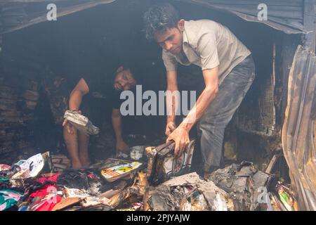 Dhaka, Bangladesch. 4. April 2023. Ladenbesitzer durchwühlen die verbrannten Trümmer, während sie versuchen, etwas zu finden, was man retten kann. Im Morgengrauen des 4. April 2023 brach in Bangabazar, einem der größten Stoffmärkte in Dhaka, Bangladesch, ein massives Feuer aus. Dem Vernehmen nach begann der Brand in einer der Läden um ca. 6 UHR MORGENS und breitete sich schnell auf den Rest des Marktes aus. Das Feuer wütete fast 7 Stunden lang, bevor es unter Kontrolle gebracht wurde. Der Brand hat erhebliche Schäden am Markt verursacht, wobei die meisten Läden und Verkaufsstände durch die Flammen zerstört wurden. (Kreditbild: © Rizwan Hasan/Pacific Press via ZUMA Pre Stockfoto