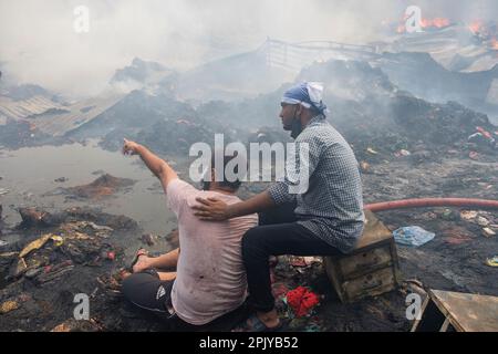 Dhaka, Bangladesch. 4. April 2023. Deprimierte Ladenbesitzer sitzen verzweifelt, während das Feuer wütet.am 4. April 2023 brach in Bangabazar, einem der größten Stoffmärkte in Dhaka, Bangladesch, ein massives Feuer aus. Dem Vernehmen nach begann der Brand in einer der Läden um ca. 6 UHR MORGENS und breitete sich schnell auf den Rest des Marktes aus. Das Feuer wütete fast 7 Stunden lang, bevor es unter Kontrolle gebracht wurde. Der Brand hat erhebliche Schäden am Markt verursacht, wobei die meisten Läden und Verkaufsstände durch die Flammen zerstört wurden. (Kreditbild: © Rizwan Hasan/Pacific Press via ZUMA Press Wire) NUR REDAKTIONELLE VERWENDUNG! Nein. Nein Stockfoto