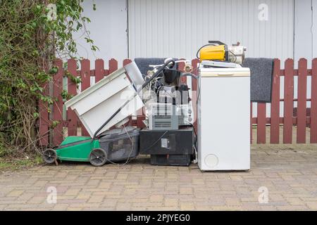 Sperriger Müllhaufen mit alten elektronischen Geräten am Straßenrand Stockfoto