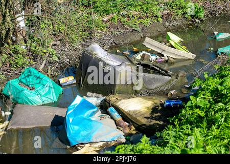 Denham, Buckinghamshire, Großbritannien. 4. April 2023. In Denham, Buckinghamshire, gibt es in einem Bach erschütternde Mengen an Fliegenscheitern und Müll, darunter Asbestplatten, Reifen, ein Gefrierschrank, Motorölbehälter und Plastik. Die Regierung hat härtere Maßnahmen für diejenigen angekündigt, die wegen unsozialem Verhalten einschließlich illegalem Fliegenlassen verurteilt werden. Kredit: Maureen McLean/Alamy Live News Stockfoto