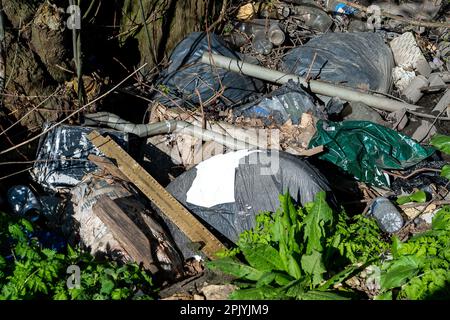 Denham, Buckinghamshire, Großbritannien. 4. April 2023. In Denham, Buckinghamshire, gibt es in einem Bach erschütternde Mengen an Fliegenscheitern und Müll, darunter Asbestplatten, Reifen, ein Gefrierschrank, Motorölbehälter und Plastik. Die Regierung hat härtere Maßnahmen für diejenigen angekündigt, die wegen unsozialem Verhalten einschließlich illegalem Fliegenlassen verurteilt werden. Kredit: Maureen McLean/Alamy Live News Stockfoto