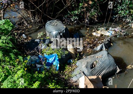 Denham, Buckinghamshire, Großbritannien. 4. April 2023. In Denham, Buckinghamshire, gibt es in einem Bach erschütternde Mengen an Fliegenscheitern und Müll, darunter Asbestplatten, Reifen, ein Gefrierschrank, Motorölbehälter und Plastik. Die Regierung hat härtere Maßnahmen für diejenigen angekündigt, die wegen unsozialem Verhalten einschließlich illegalem Fliegenlassen verurteilt werden. Kredit: Maureen McLean/Alamy Live News Stockfoto