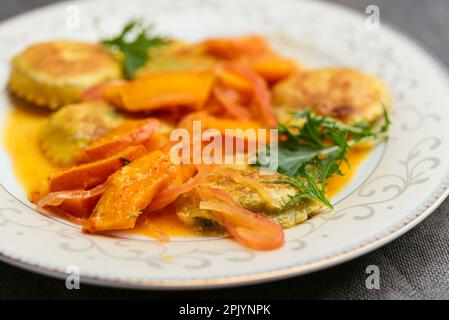 Hausgemachte Ravioli mit einem Rucola-Pesto mit rotem Kuri-Kürbis und Orangensoße. Stockfoto