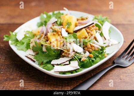 Tropischer Linsensalat mit Ananas- und Kokosnuss-Chips. Stockfoto