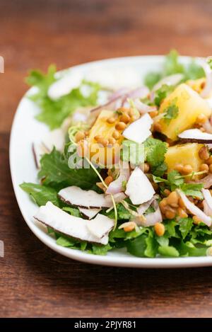 Tropischer Linsensalat mit Ananas- und Kokosnuss-Chips. Stockfoto