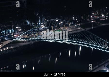 Blick aus der Perspektive auf die Zubizuri-Brücke bei Nacht in Bilbao, Spanien Stockfoto