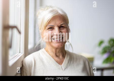 Porträt einer lächelnden Seniorin, die in die Kamera schaut Stockfoto