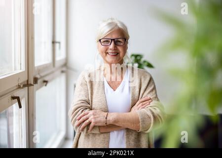 Porträt einer lächelnden Seniorin, die in die Kamera schaut Stockfoto