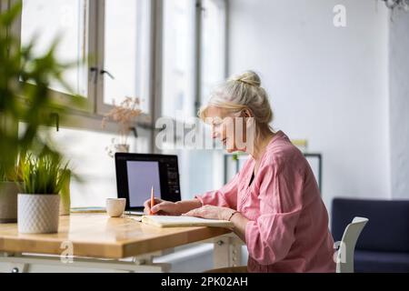 Porträt einer lächelnden, reifen Geschäftsfrau, die in einem Büro arbeitet Stockfoto