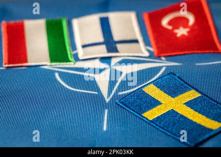 Flaggen der türkei, finnlands und ungarns vor dem Hintergrund des NATO-Symbols, Schwedens Flagge gegenüber, Konzept, schwierige Verhandlungen und gemeinsames Vorgehen Stockfoto