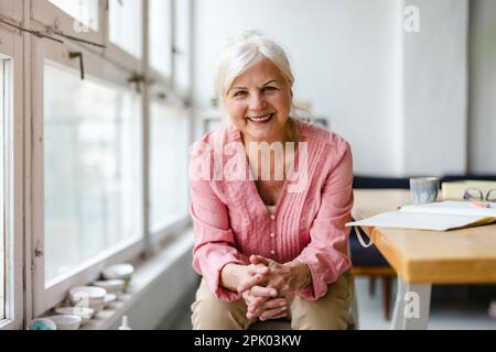 Porträt einer lächelnden Seniorin, die in die Kamera schaut Stockfoto