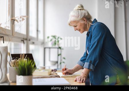 Porträt einer lächelnden, reifen Geschäftsfrau, die in einem Büro arbeitet Stockfoto