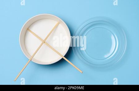 Öffnen Sie die leere Nudelschüssel mit einem Paar Holzstäbchen auf blauem Hintergrund, Draufsicht Stockfoto