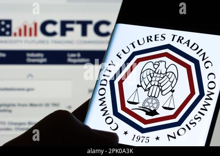 CFTC-Logo der Commodity Futures Trading Commission auf dem Bildschirm des Smartphones, das im Dunkeln in den Händen gehalten wird. Stafford, Großbritannien, 3. April 2023. Stockfoto