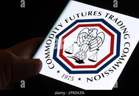 CFTC-Logo der Commodity Futures Trading Commission auf dem Bildschirm des Smartphones, das im Dunkeln in den Händen gehalten wird. Stafford, Großbritannien, 3. April 2023. Stockfoto