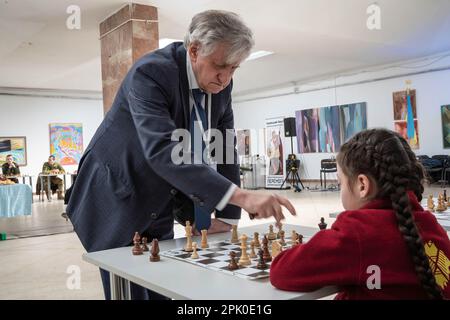 Ein Kind spielt Schach bei einer gleichzeitigen Schachsitzung mit dem internationalen Großmeister Oleg Romanyshyn. Zivilisten, Militär und Kinder besuchten ein gleichzeitiges Schachspiel „FrühjahrsGegenoffensive“ unter Beteiligung der internationalen Großmeister Marta Litynska, Oleg Romanyshyn, Oleksandr Belyavskyi, Adrian Mikhalchyshyn zur Unterstützung der ukrainischen Streitkräfte im Lemberg-Palast der Künste in Lemberg, Ukraine. 68 Teilnehmer und 4 Großmeister nahmen gleichzeitig an dem Spiel Teil, um Gelder für die ukrainische Armee zu sammeln. (Foto: Olena Znak/SOPA Images/Sipa USA) Stockfoto