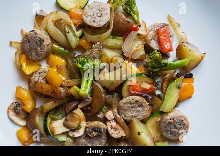 Französisch geröstete Zwiebelwurst mit Kartoffeln, Pilzen, Brokkoli, Zwiebeln, Gelb, Rote, grüne Paprika, Zucchini-Gericht. Stockfoto