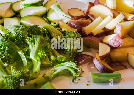 Schneiden Sie Brokkoli, rote Kartoffeln und Zucchini auf dem Schneidebrett. Stockfoto