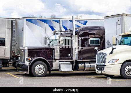 Großlaster in Industriequalität, amerikanische Motorhaube, klassischer lilafarbener Sattelauflieger mit erweiterter Fahrerkabine für den Komfort des Lkw-Fahrers, Stand mit Auflieger für Trockentransporter Stockfoto