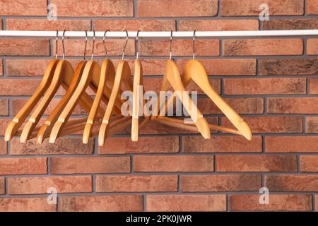 Kleiderbügel aus Holz in der Nähe von roten Backsteinwänden Stockfoto