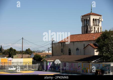 Watts, Kalifornien, USA - 25. Februar 2023: Die Nachmittagssonne scheint auf eine historische Kirche und ein historisches Viertel. Stockfoto