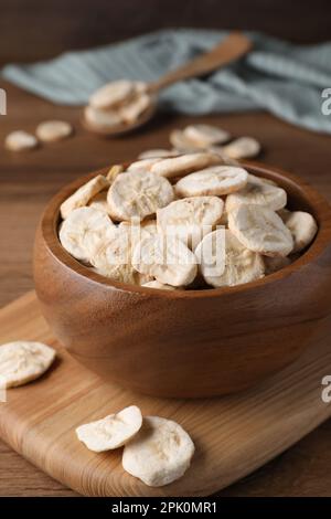 Schüssel mit getrockneten Bananenscheiben auf Holztisch, Nahaufnahme Stockfoto