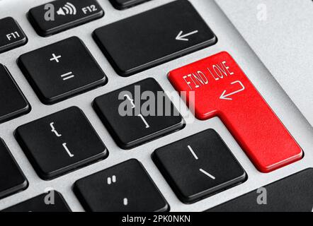 Online-Dating. Roter Knopf mit den Worten "Liebe finden" auf der Computertastatur, Nahaufnahme Stockfoto