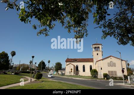 Watts, Kalifornien, USA - 25. Februar 2023: Die Nachmittagssonne scheint auf eine historische Kirche und ein historisches Viertel. Stockfoto