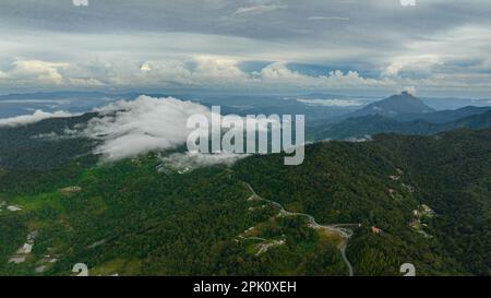 Ackerland und Bauerndorf in den Bergen aus der Vogelperspektive. Borneo, Sabah, Malaysia. Stockfoto