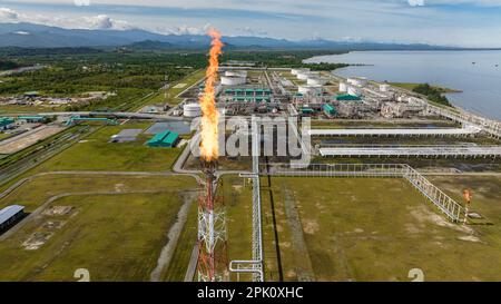 Gasfackeln auf einem großen Industriekomplex und einer Ölraffinerie. Das Ölterminal ist eine Industrieanlage zur Lagerung von Öl und petrochemischen Produkten. Borneo, Sabah, Malaysia. Stockfoto