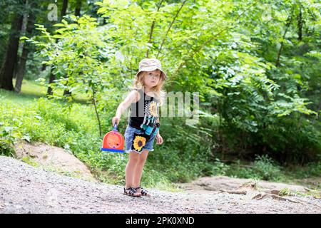 Ein kleines, kaukasisches Kleinkind fing sich beim Naturspaziergang einen Käfer. Kind erforscht Insekten. Wandern mit einem Kleinkind. Kind erforscht die Natur. Stockfoto