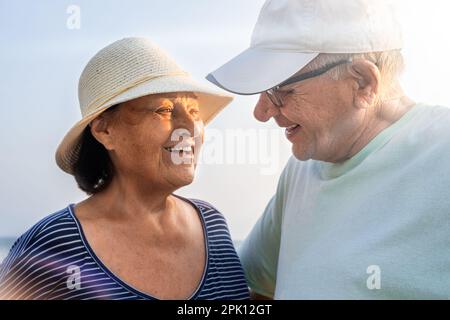Das Seniorenpaar schaut sich liebevoll an der Küste an Stockfoto