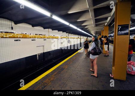 Passagiere warten auf dem Bahnsteig der 7. Avenue Station in Manhattan, New York City. Stockfoto