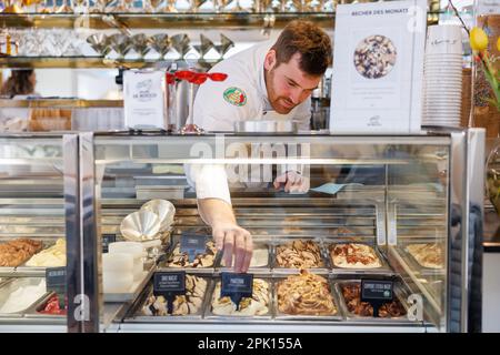 Schwabach, Deutschland. 23. März 2023. Der Eiscreme-Hersteller Luca de Rocco stellt in seinem Eiscafé ein Schild mit der Aufschrift „Marzipan“ auf einen Eisbehälter. Noch bevor die Eissaison wirklich losgeht, ist eines sicher: Veganes Eis wird weiterhin trendig sein. Aber auf welche neuen Geschmacksrichtungen können sich Eiscreme-Fans dieses Jahr freuen? (Zu dpa: "Fruit Prosecco oder klassische Vanille? The Ice Cream Trends 2023') Kredit: Daniel Karmann/dpa/Alamy Live News Stockfoto